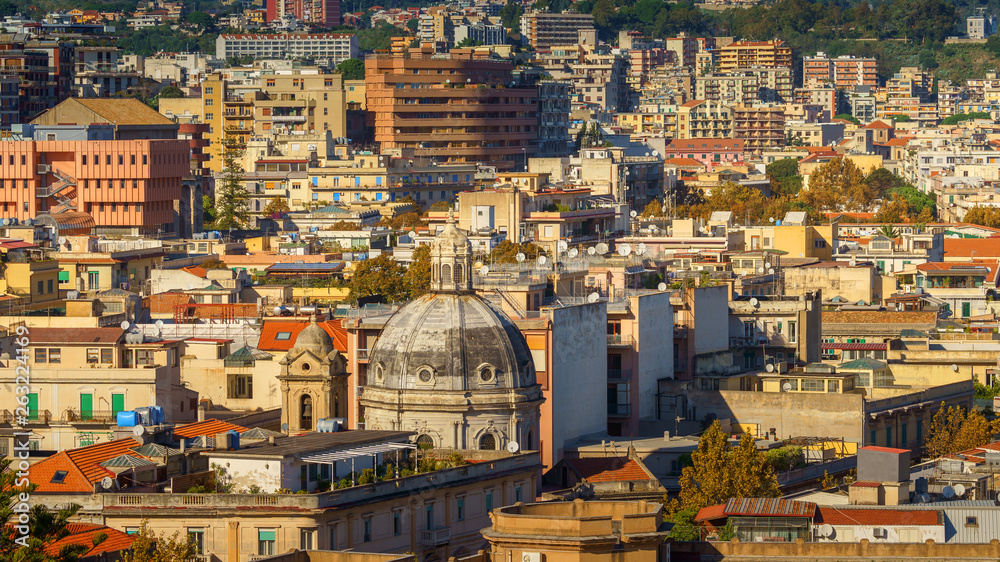 Fototapeta premium Panoramic top view of the local buildings with the trees, mountains and the sky in the beautiful city of Messina, Sicily, Italy