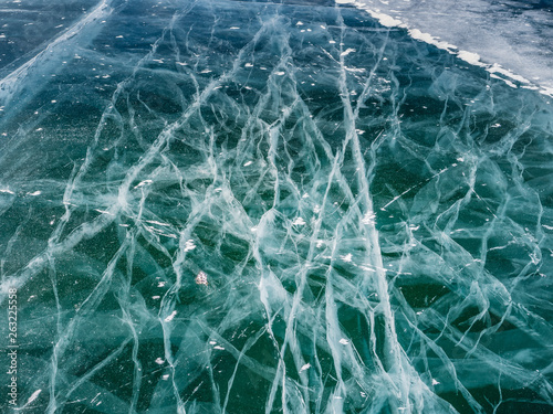 Network of cracks in thick solid layer of ice of a frozen surface Baikal lake in Siberia (Russia)