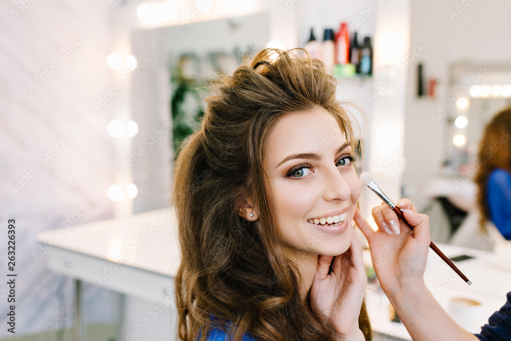 Stylish closeup portrait of gorgeous young woman with beautiful coiffure smiling in hairdresser salon. Making makeup, stylist, professional, cheerful mood, world of beauty, hairdressing service Stylish closeup portrait of gorgeous young woman with beautiful coiffure smiling in hairdresser salon. Making makeup, stylist, professional, cheerful mood, world of beauty, hairdressing service