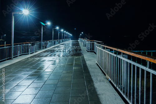 Fototapeta Naklejka Na Ścianę i Meble -  Night scene in blue with a silhouette.  Bridge at the port of Pomorie, Bulgaria.