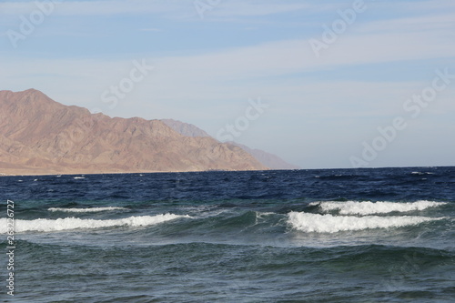 Sea with waves and mountains on the horizon