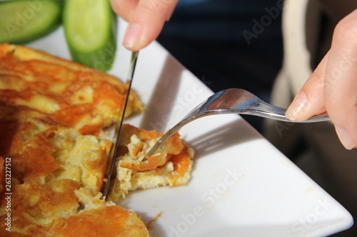 Cutting the amlet with a knife and fork for breakfast photo