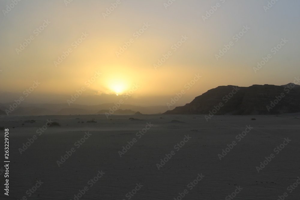 Sunset in the desert with dunes and rocky mountains Sunset in the desert with dunes and rocky mountains