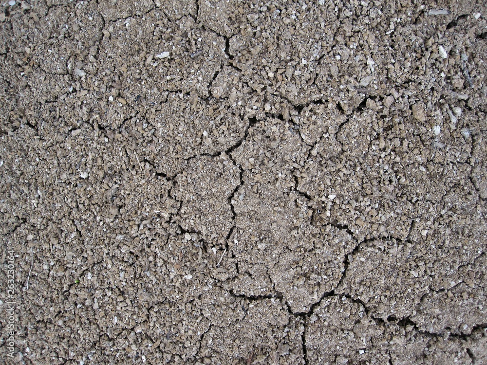 Cracked clay land, sand and pebbles Cracked clay land, sand and pebbles