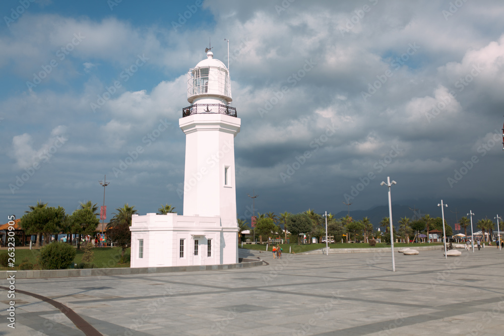 Batumi, Georgia - 29 August 2018: White Lighthouse with cloud sky on the background