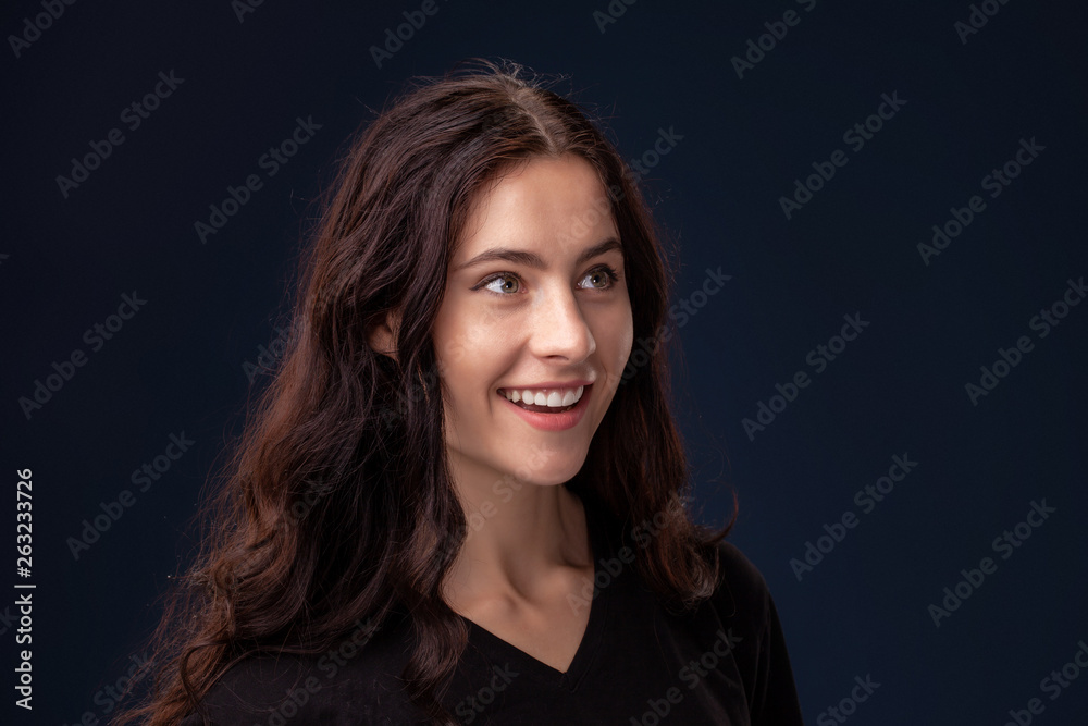 Close-up portrait of a beautiful brunette with curly hair and professional make-up posing on a black background. Close-up portrait of a beautiful brunette with curly hair and professional make-up posing on a black background.