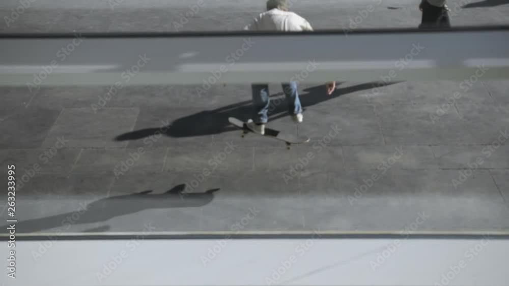 Young skateboarder lands a difficult trick while skating in the urban skate park. Unrecognizable skaters does different tricks in public skate park outdoors.