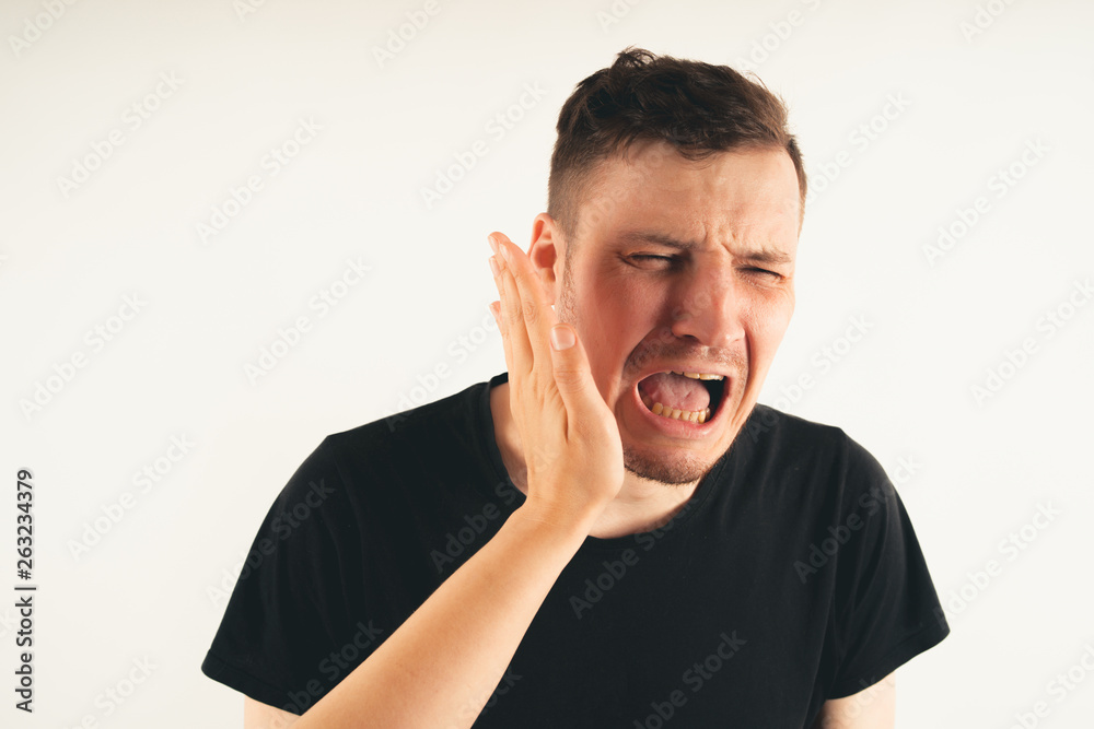 Crop person slapping scared man in face. Emotional male getting slapped in face while shouting with closed eyes in fear on white background Crop person slapping scared man in face. Emotional male getting slapped in face while shouting with closed eyes in fear on white background