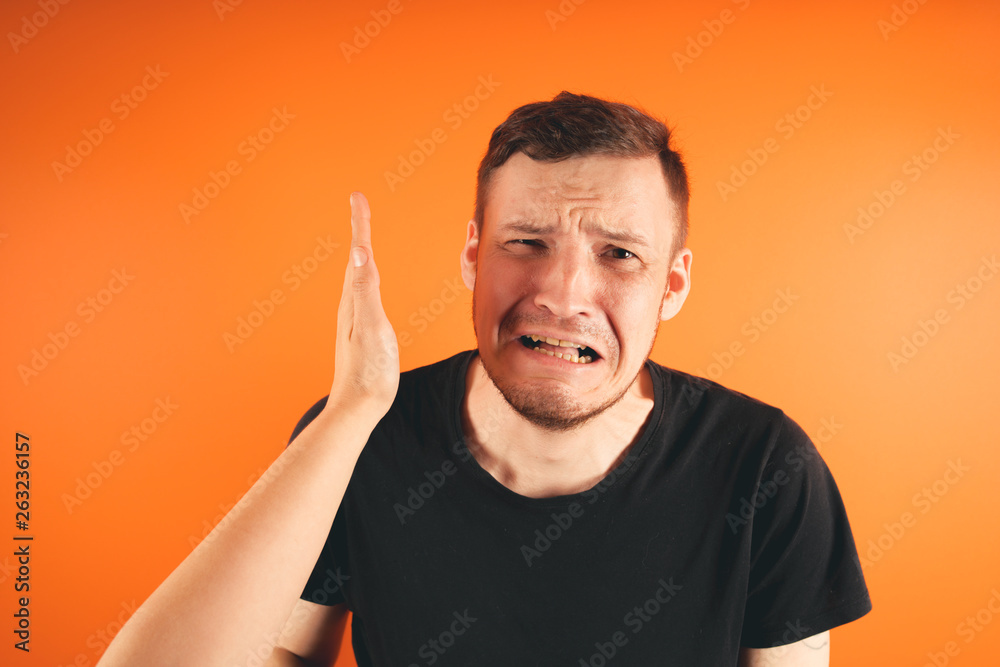 Man getting slapped on orange background Unhappy scared man getting slapped standing on orange background Man getting slapped on orange background Unhappy scared man getting slapped standing on orange background