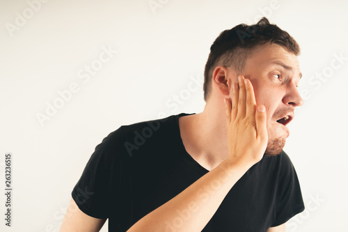 Fototapeta Emotional male getting slapped in face while shouting with closed eyes in fear o
