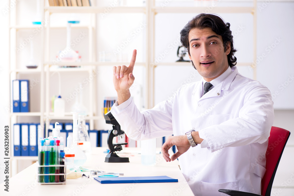 Young handsome chemist working in the lab Young handsome chemist working in the lab