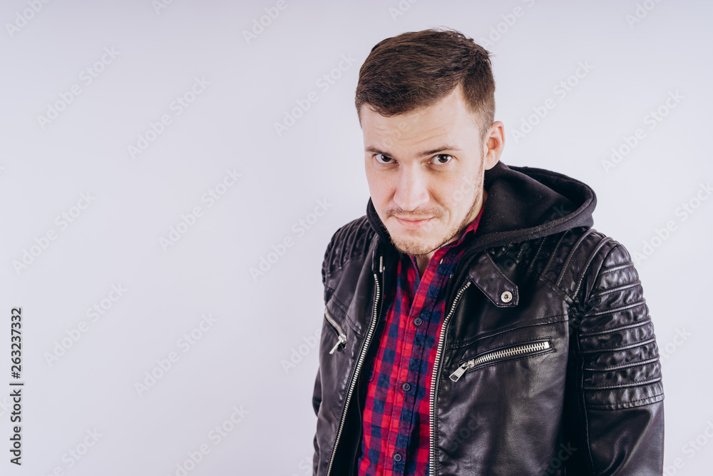 Man in trendy jacket on white background Portrait of young male in leather jacket zipping up and smiling at camera on white background Man in trendy jacket on white background Portrait of young male in leather jacket zipping up and smiling at camera on white background