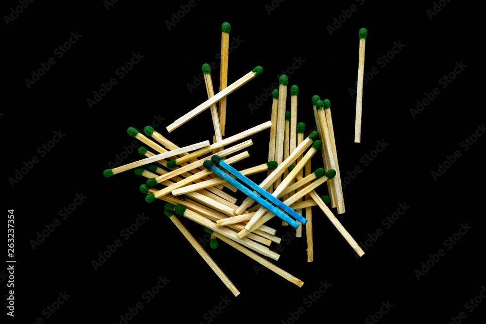 homosexuality concept: 2 blue matches opposite a pile of ordinary matches, black background homosexuality concept: 2 blue matches opposite a pile of ordinary matches, black background