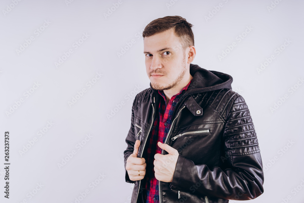 Man in trendy jacket on white background Portrait of young male in leather jacket zipping up and smiling at camera on white background Man in trendy jacket on white background Portrait of young male in leather jacket zipping up and smiling at camera on white background