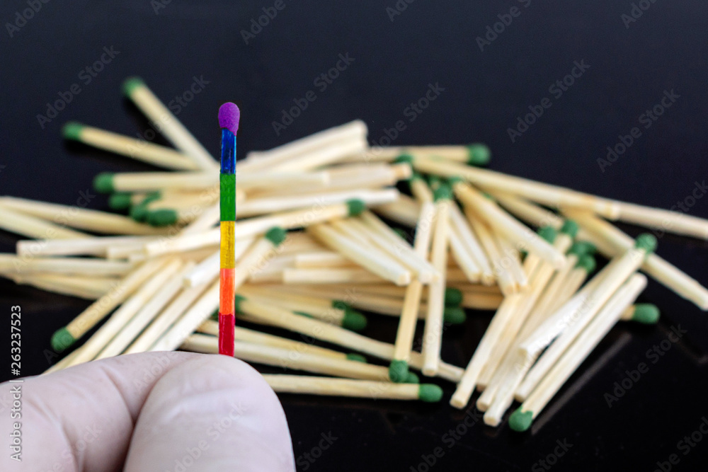 homosexuality concept: an unusual match of the iridescent color of LGBT symbolism opposite to ordinary matches