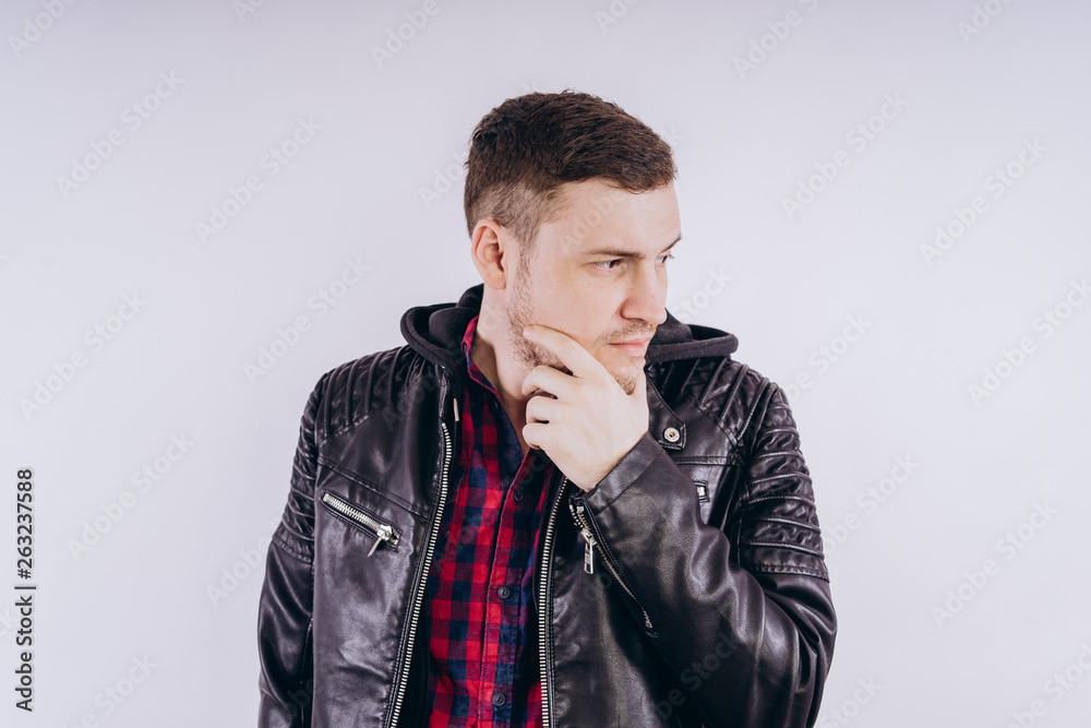 Man in trendy jacket on white background Portrait of young male in leather jacket zipping up and smiling at camera on white background Man in trendy jacket on white background Portrait of young male in leather jacket zipping up and smiling at camera on white background