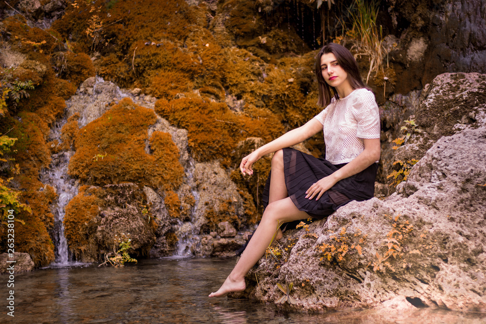 Beautiful girl posing in river, fairy fast forest in autumn.  Beauty, fashion. Spa, healthcare. Tropical vacation. Natural pool.
