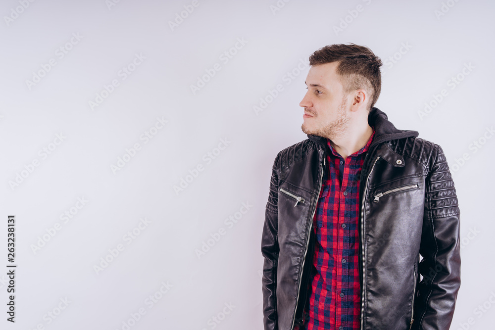 Man in trendy jacket on white background. Portrait of young male in leather jacket zipping up and smiling at camera on white background Man in trendy jacket on white background. Portrait of young male in leather jacket zipping up and smiling at camera on white background
