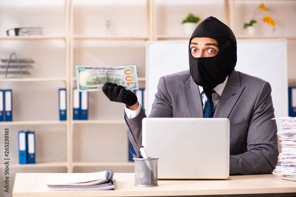 Male gangster stealing information from the office Male gangster stealing information from the office