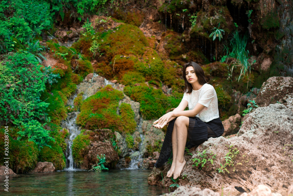 Beautiful dark haired girl posing in river with green plants. Beauty, fashion. Spa, healthcare. Tropical vacation. Natural pool. Beautiful dark haired girl posing in river with green plants. Beauty, fashion. Spa, healthcare. Tropical vacation. Natural pool.