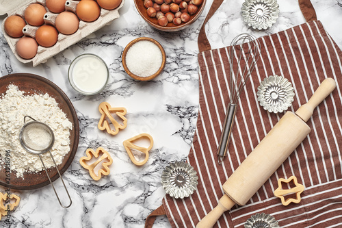 Close-up shot. Top view of a baking ingredients and kitchenware on the marble table background.
