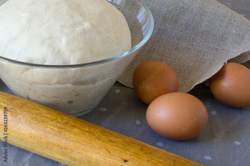 Fresh raw dough in a glass bowl with eggs. Fresh raw dough in a glass bowl with eggs.