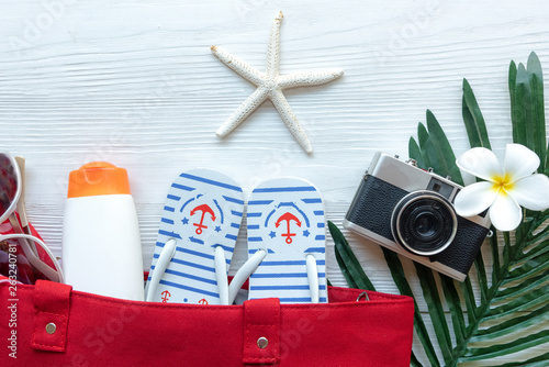 Travel Plan. Traveler planning trips summer vacations on the beach with Traveler accessories, retro camera, sunblock, sunglass and passport in summertime. Top view and copy space for banner