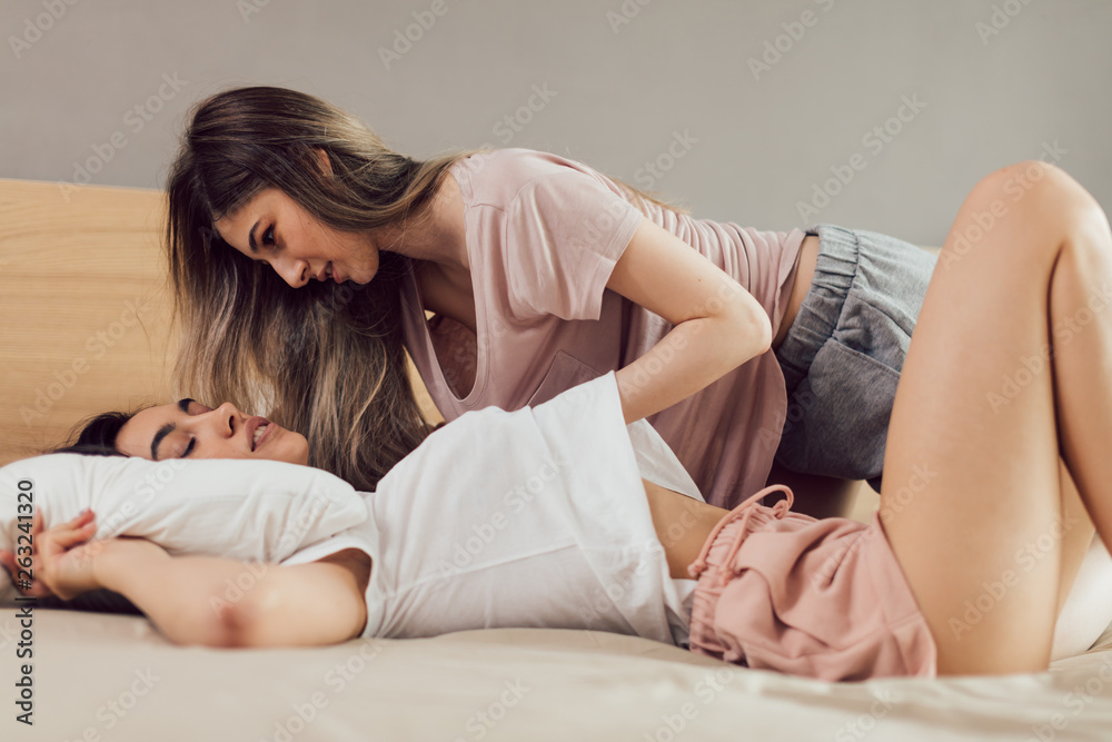 sexy girl with hand under her girlfriend lying on the bed. close up cropped  photo. Stock Photo | Adobe Stock