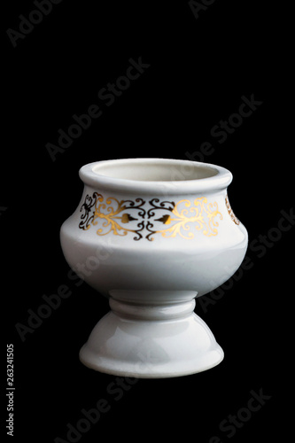 white porcelain aromatic lampada with a gold pattern on a black background, short focus