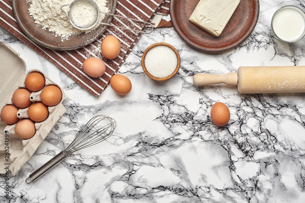 Close-up shot. Top view of a baking ingredients and kitchenware on the marble table background. Close-up shot. Top view of a baking ingredients and kitchenware on the marble table background.