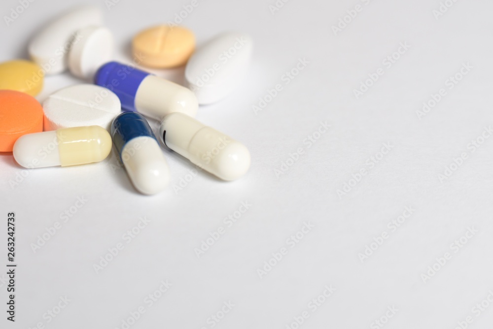 A close-up photo of various medical pills and capsules spilt on white background A close-up photo of various medical pills and capsules spilt on white background