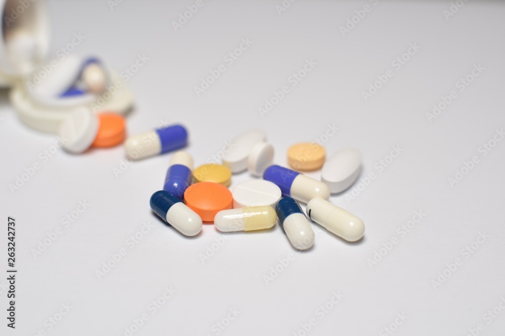 A close-up photo of various medical pills and capsules spilt on white background A close-up photo of various medical pills and capsules spilt on white background