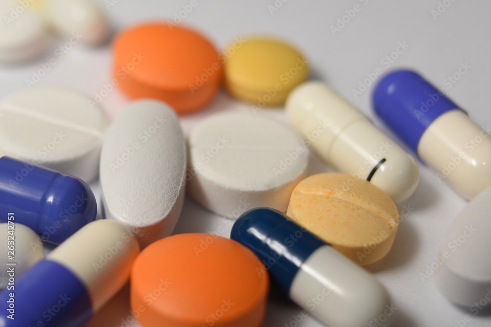 A close-up photo of various medical pills and capsules spilt on white background A close-up photo of various medical pills and capsules spilt on white background