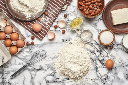 Close-up shot. Top view of a baking ingredients and kitchenware on the marble table background.