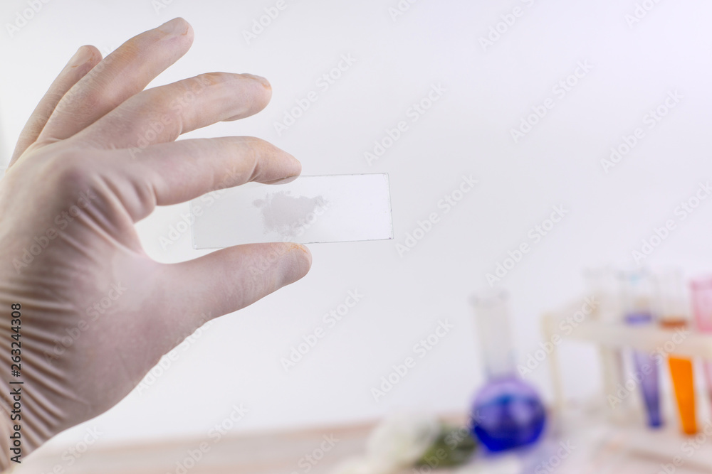 the problem of synthetic psychotropics: a person shows a sample of an unknown powder above the table with other samples, short focus the problem of synthetic psychotropics: a person shows a sample of an unknown powder above the table with other samples, short focus