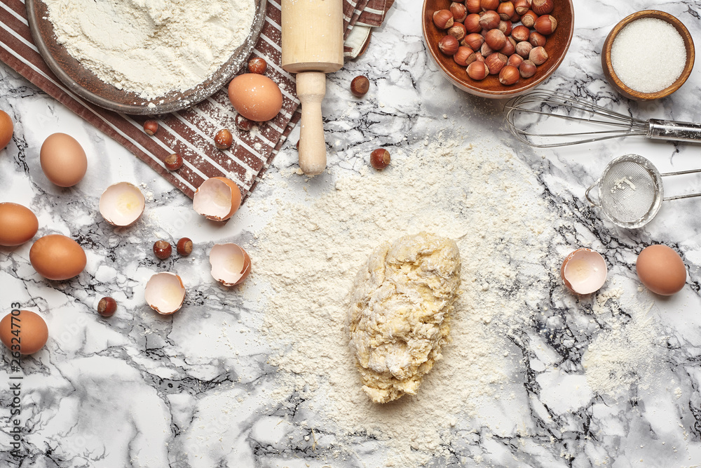 Close-up shot. Top view of a baking ingredients and kitchenware on the marble table background. Close-up shot. Top view of a baking ingredients and kitchenware on the marble table background.