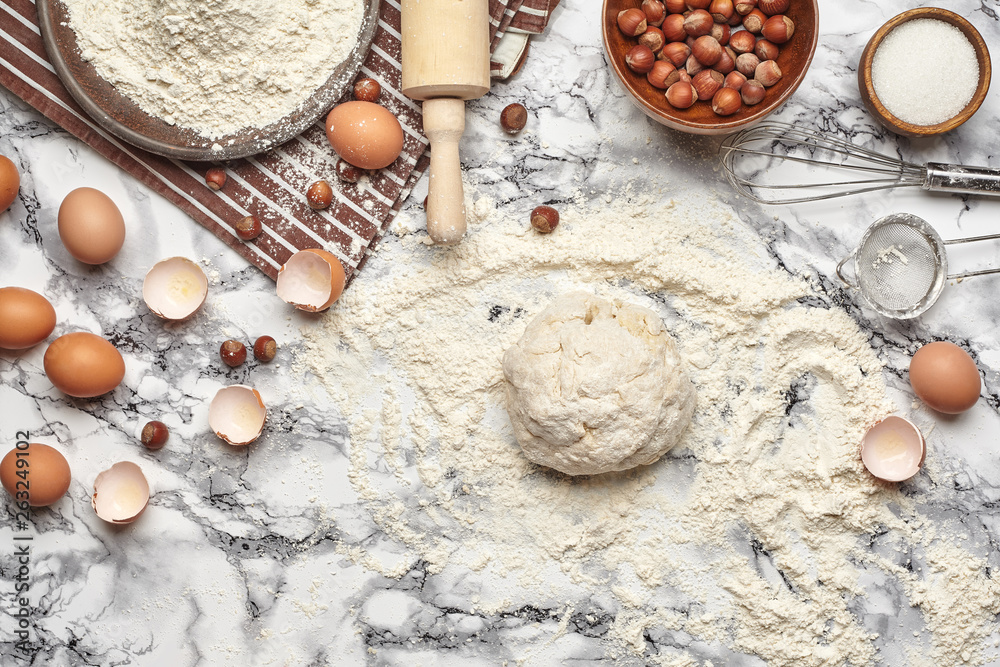Close-up shot. Top view of a baking ingredients and kitchenware on the marble table background.