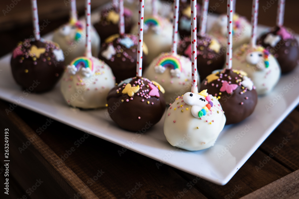 Obraz premium Cake pops on white plate on top of wooden box