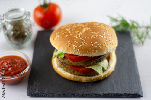 seitan burger with tomato ketchup spices and lettuce, vegan and healthy food