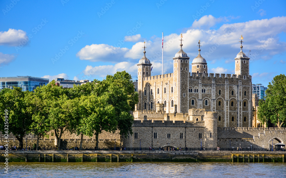 View of the Tower of London, a castle and a former prison in London, England, from the River Thames. The Tower of London, today a museum, is a fortified complex that includes multiple buildings
