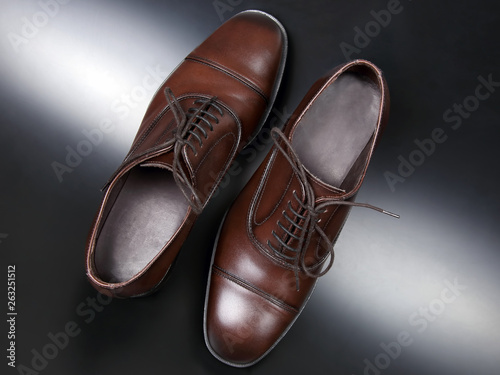 Classic men's brown Oxford shoes on dark background