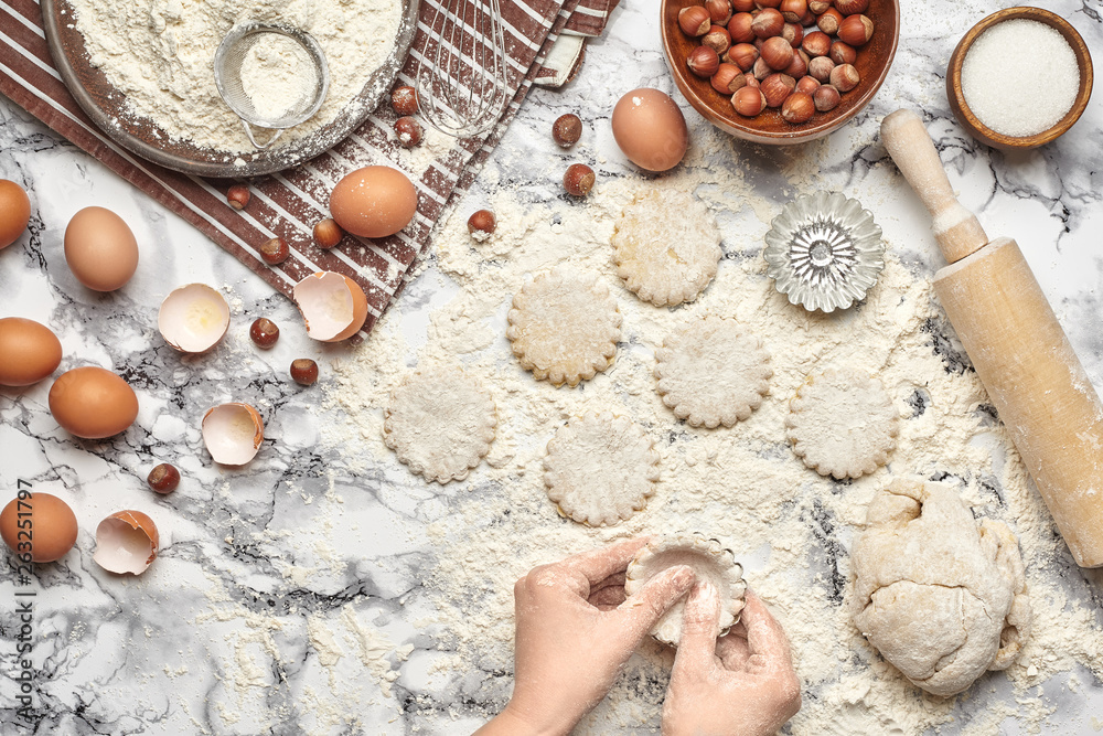 Close-up shot. Top view of a baker cook place, hands are working with a raw dough on the marble table background. Close-up shot. Top view of a baker cook place, hands are working with a raw dough on the marble table background.