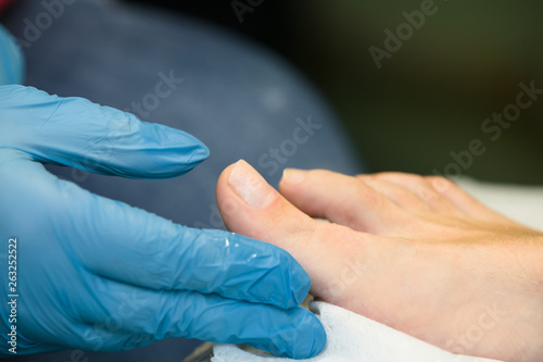 Survey of nails on a leg in the procedure of manicure at the woman