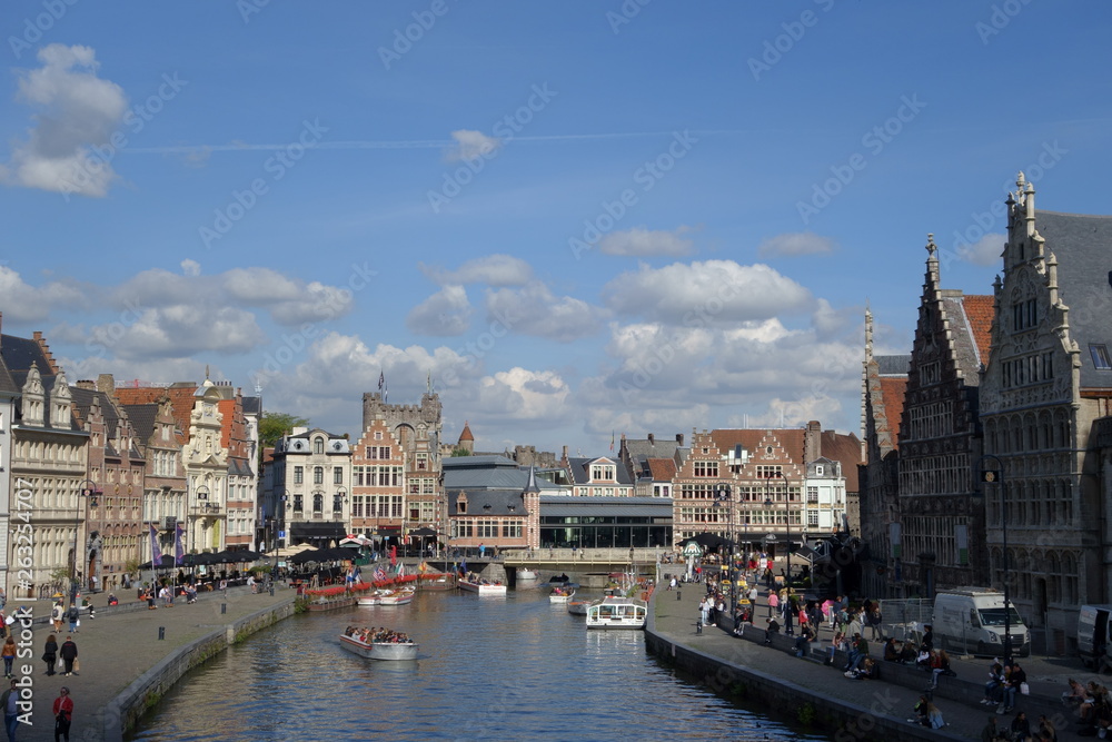 Wide view to the Leie embankments with buildings, boats and the castle of the Princes of Flanders in the background (Ghent, Belgium)