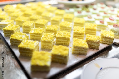 Lemon mousse cake slices or sweet dessert on a luxury gourmet buffet or in a bakers shop window