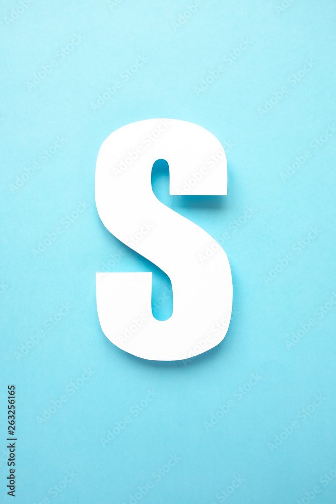 letter s cut from paper on blue background
