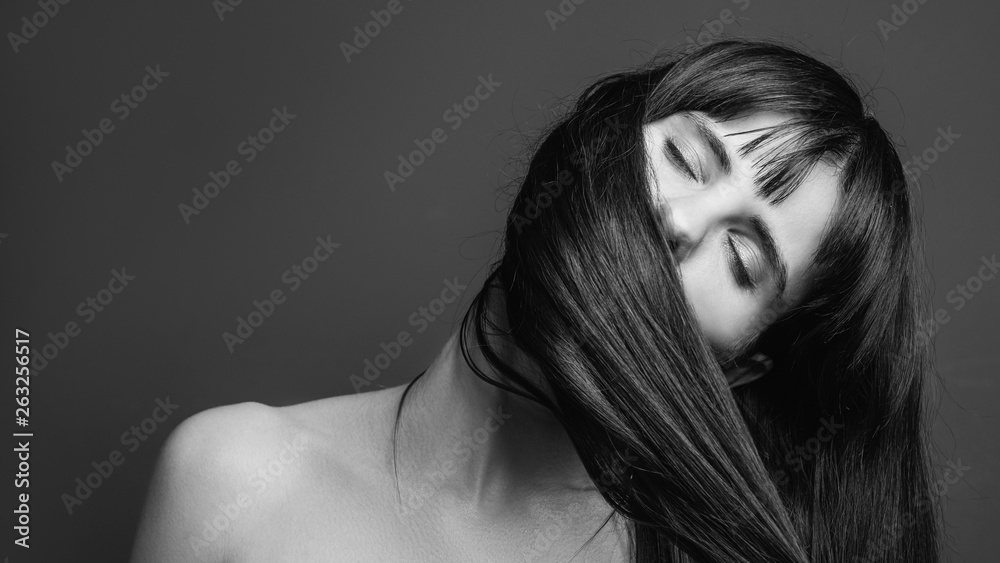 Organic shampoo. Professional beauty care. Black and white closeup portrait of emotional brunette lady enjoying smell of her hair. Organic shampoo. Professional beauty care. Black and white closeup portrait of emotional brunette lady enjoying smell of her hair.