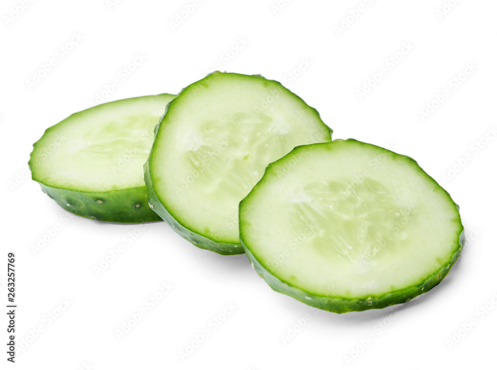 A few slices of cucumber lying in a pile on top of each other. White isolated background. Close-up. Side view. A few slices of cucumber lying in a pile on top of each other. White isolated background. Close-up. Side view.