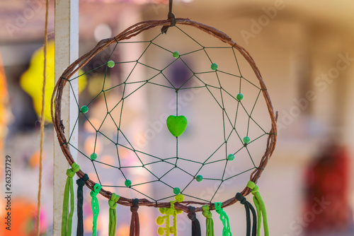 Green dream catcher with artificial heart in the middle.Made of wood and tissue.