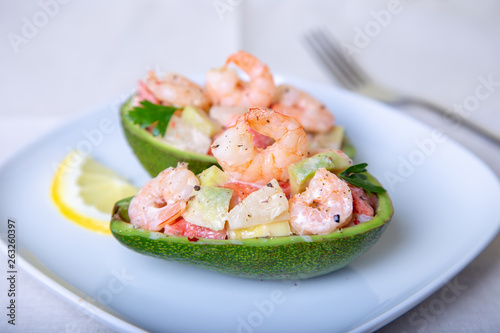 Salad with shrimps, avocado, pineapple and grapefruit in half avocado. Selective focus, close-up.